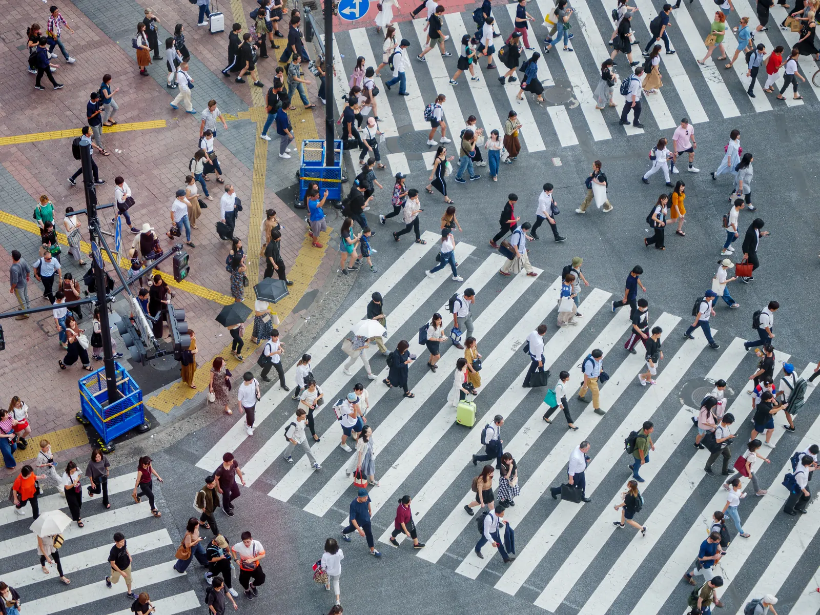 A busy crossing seen from above: hundreds of pedestrians crossing the zebra crossings at once.